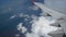 4K footage. flight over the rainbow. aerial view through an airplane window. wing airplane and beautiful white clouds in blue sky