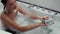 4K footage: Joyful woman in foamy bath using a loofah