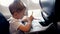 4k footage of little smiling boy drawing on passenger seat at aircraft during flight