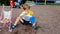 4k footage of little toddler boy digging sand with scoop and pouring it in plastic toy bucket