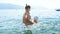 4k footage of little toddler boy in hat learning swimming in sea with mother