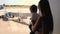 4k footage of oyung mother with toddler son looking at jet airplanes on runway at international airport terminal
