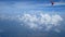 4K footage. Traveling by air. Aerial view through an airplane window. Wing airplane and beautiful white clouds in blue sky