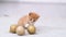 4k Ginger red little curious striped kitten playing with golden Christmas ball at home on grey floor. Cat pushes and