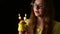 4k Happy attractive young woman holding one muffin with two heart shape candle, blows out the candles.