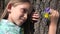 4K Happy child portrait playing in park, girl face with spring flowers in nature