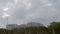 4K high-motion shooting of clouds movements along the sky with a round building standing still far away