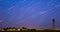 4k Hyperlapse Amazing Unusual Stars Effects In Sky. Stars Lines Move Above Rural Landscape Water Tower In Background