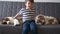 4k. little boy playing with two Small Australian shepherd puppy dog on couch