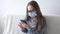 4k. little cute caucasian girl in glasses protective face mask study in phone