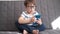 4k. little cute caucasian preschool boy in glasses study in phone