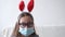 4k. little exiceted girl in face protective mask in bunny ears. easter