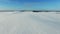 4K. Low flight above snow fields in winter, aerial panoramic view snow desert