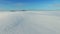 4K. Low flight and takeoff above snow fields in winter, aerial panoramic view snow desert