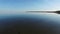 4K. Magic flight with birds over the sea at sunset above stones in the water, aerial view