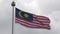 4K Malaysian flag waving in wind on flagpole at Kuala Lumpur. Cloudy weather