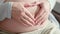 4k Mother love. Pregnant expectant mother caressing her belly, making heart hands. waiting child. Preparation for