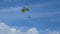 4K parasailing activity. colorful parasailing wing flying with tourist in the blue cloudy sky, extreme sport, summer activities