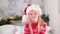 4k Portrait Christmas girl. Smiling child in Santa Claus hat looking into the camera at home.