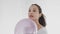 4K portrait of young beautiful female with dark hair and ponytail playing with balloon and attentively tracking its