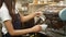 4K. professional barista making a cup of coffee. bartender pouring milk foam in front of coffee maker machine, preparing latte art