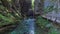 4K. Radovna river flows in Vintgar Gorge. Wooden trails and bridges. Clean blue water and green forest. Triglav National Park.