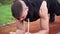 4k resolution closeup tilt movement video of young fit man doing plank exercise in the morning outdoor on the running