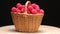 4K. Ripe raspberries in a wicker basket rotate on a black background