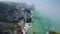 4K Rugged rocks at at atlantic coastline in morning fog with Cabo da Roca Lighthouse in background in Sintra, Portugal