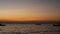 4K. silhouette of small boat over the sea with small wave at sunset or sunrise time, beautiful sunlight reflect with water surface