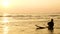 4K. silhouette of surfer man relax by sitting on surfboard over the sea at sunset on tropical beach. sport and recreation