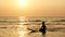 4K. silhouette of surfer man sitting on surfboard over the sea at sunset on tropical beach