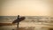 4K. silhouette of surfer man stand on the sea beach with long surf boards at sunset on tropical beach, vintage color style