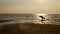 4K. Silhouette of surfer man walking into the sea with long surf boards at sunset on tropical beach