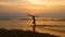 4K. silhouette of young happy surf man running with long surf boards at sunset on tropical beach. surfer on the beach in sea shore