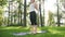 4k slow motion video of yoga and fitness on grass at park. Middle aged smiling woman practicing and doing exercises on