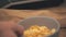 4k slowmotion video of male hand putting a bowl of cornflakes on table.