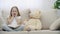 4k slowmotion video of surprised little girl touching her face with hands near teddy bear.