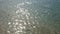 4K. sparkling fresh wavy water in the ocean is shining on a sunny summer day , abstract blurry sea beach background footage