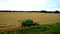 4K spectacular straight down zoom out rotating aerial view of two combine harvesters harvesting wheat