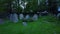4k sunrise drone footage panning over sunken headstones in an overgrown cemetery