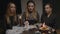 4K. Three female witches in a dark room reading tarot cards