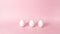 4k Three white chicken eggs dynamically emerge one at a time on light pink background. Happy Easter Day Concept. Greeting card. St