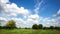 4K. Time lapse clouds over the green field.