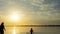 4K Time lapse of golden sunset at beach with silhouette of people on holidays