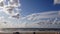 4k time lapse of north sea and sand beach with blue sky and white clouds developing and changing shape, dynamic weather