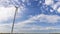 4K Time-lapse wind turbines turning. Windmill on blue sky background