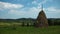 4K Timelapse of clouds and haystack on green field