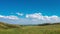 4k Timelapse yellow-green hill and sky with clouds. Wild grasses.