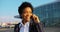 4k. Travel, digtal, business. Attractive African American woman in stylish stripped suit talks on the phone walking